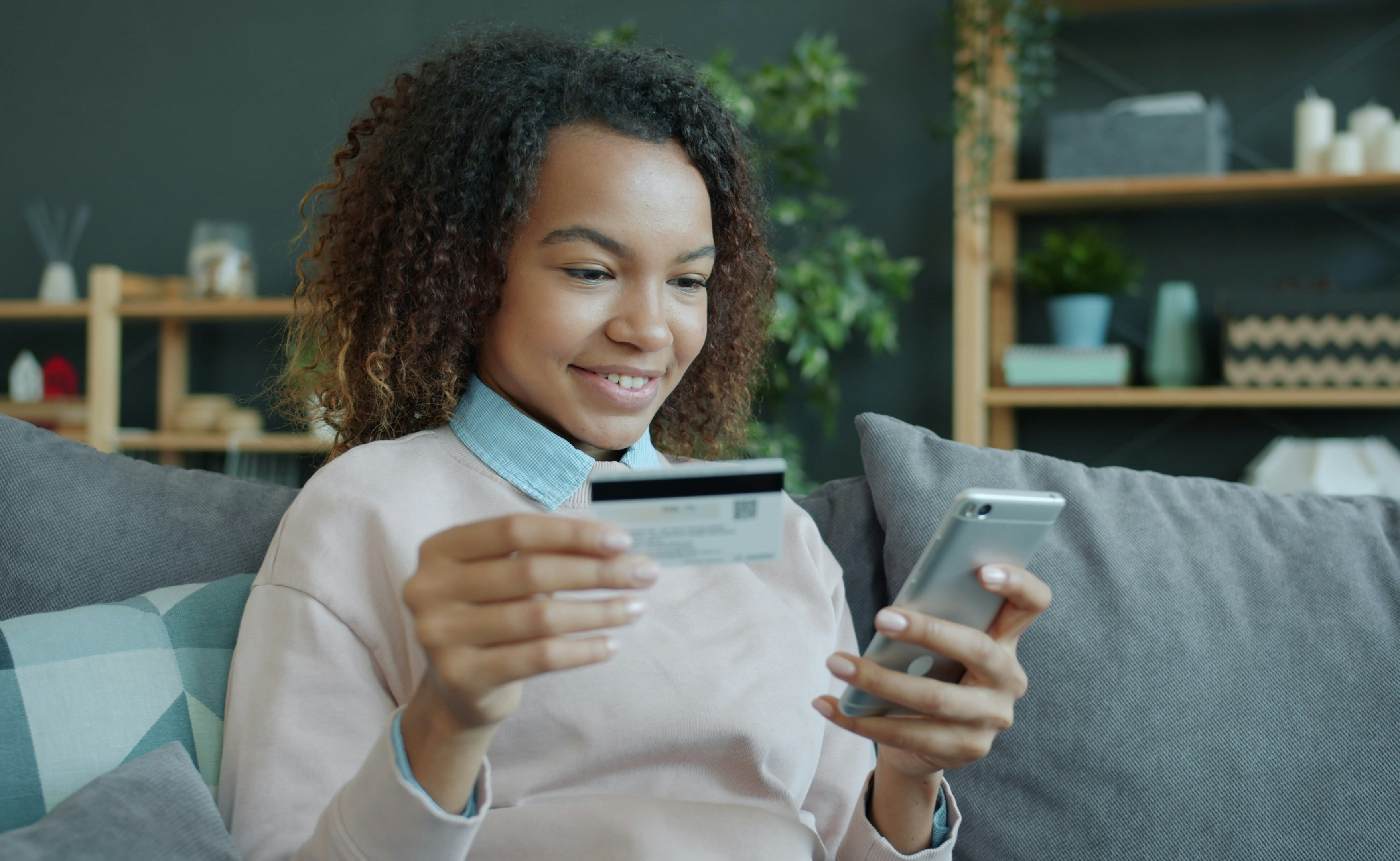 Person using a smartphone and credit card to make an online donation.