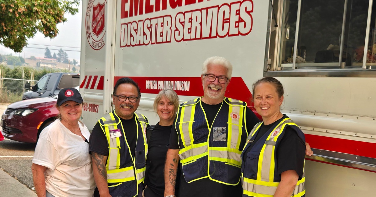 Five people stand next to an emergency disaster services truck